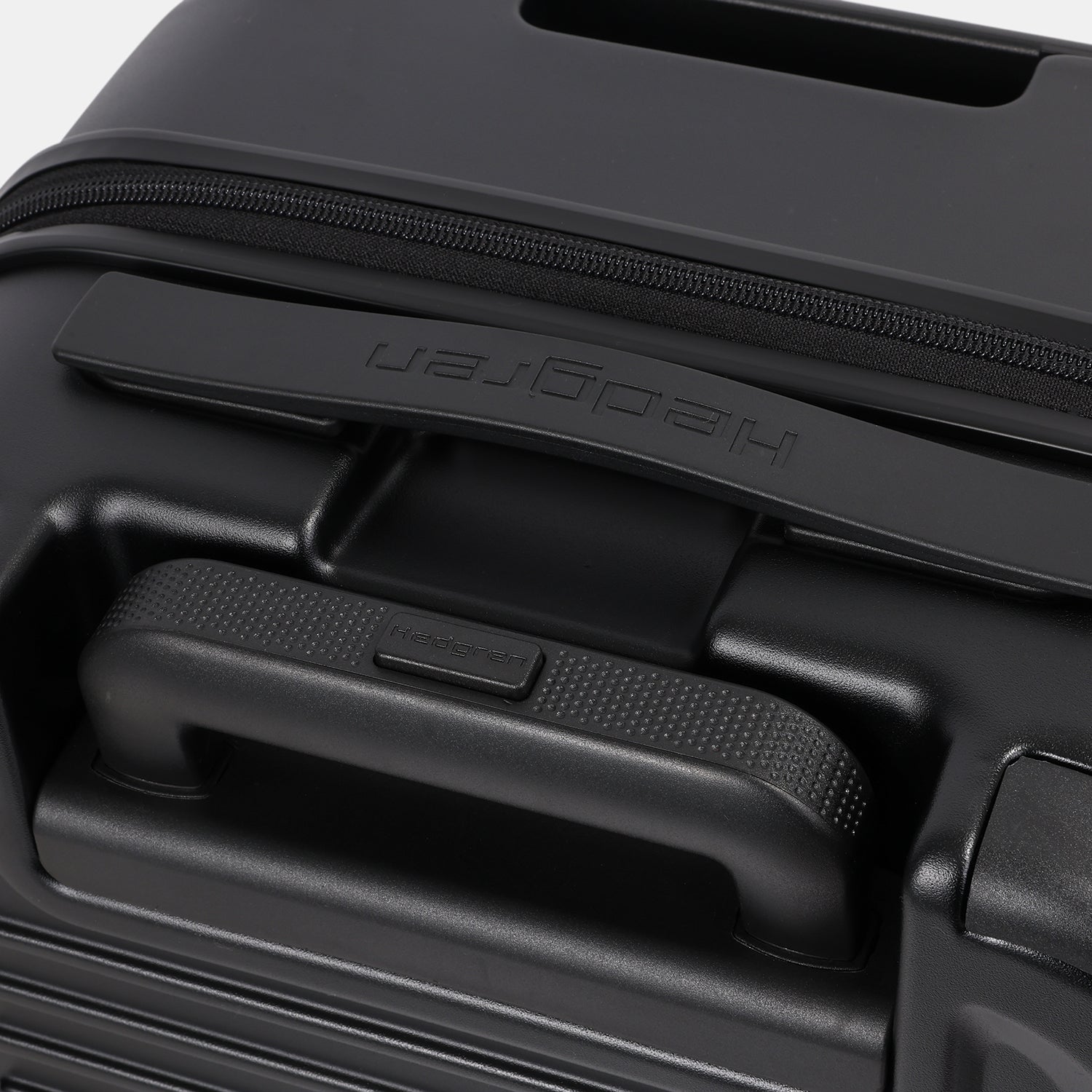 Close-up top view of the Hedgren Raku Yuno hard-shell luggage in Black, showcasing the expandable and carry handles. Shop the Latest Online